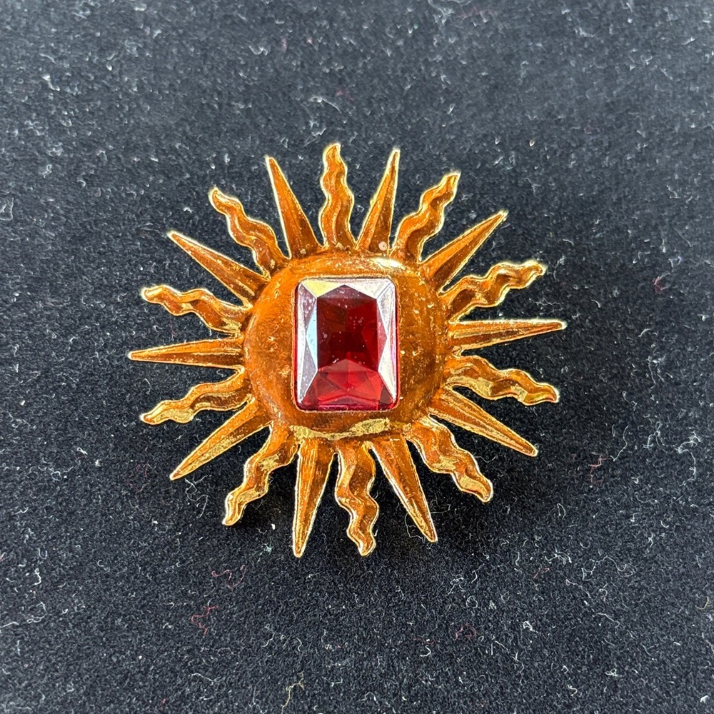 Radiant Gold Sunburst Brooch with Red Gem